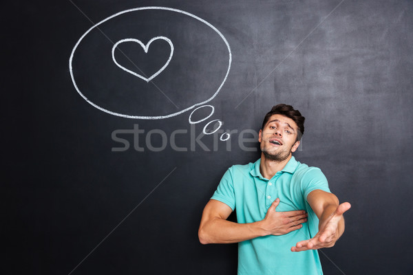 Stock photo: Man in love giving you his hand over chalkboard background