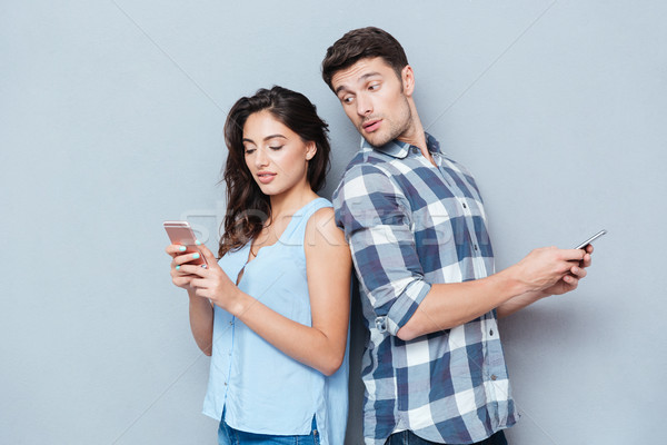 Erkek arkadaş izlerken kız arkadaş telefon kıskanç Stok fotoğraf © deandrobot