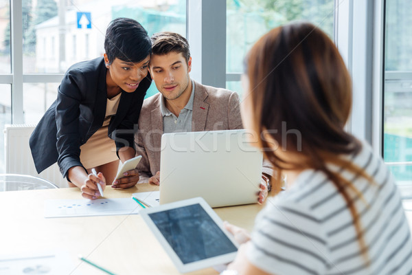 Businesspeople working with laptop, tablet and cell phone on meeting Stock photo © deandrobot