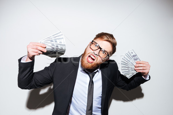 Happy business man with money in hands Stock photo © deandrobot