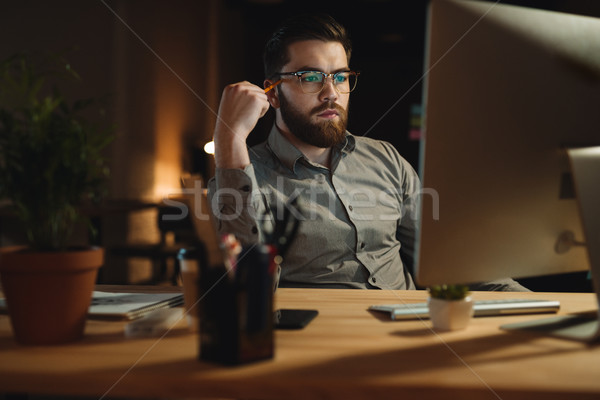 Serious bearded web designer working late at night Stock photo © deandrobot