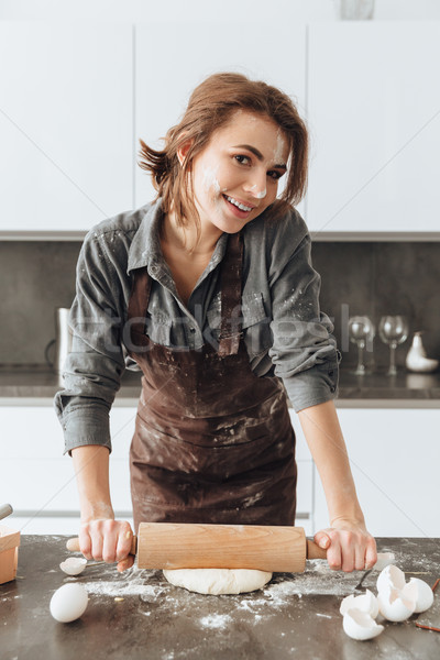 Cheerful lady standing in kitchen while cooking Stock photo © deandrobot