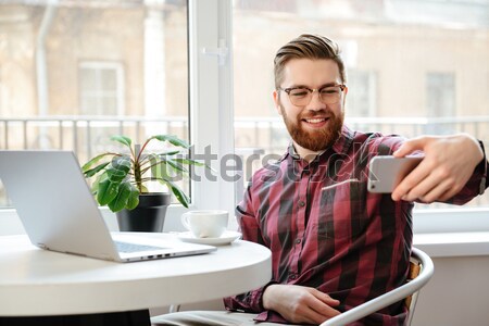 Happy bearded young man showing book to camera Stock photo © deandrobot
