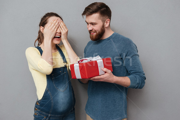 Pregnant woman with eyes closed taking gift from her husband Stock photo © deandrobot