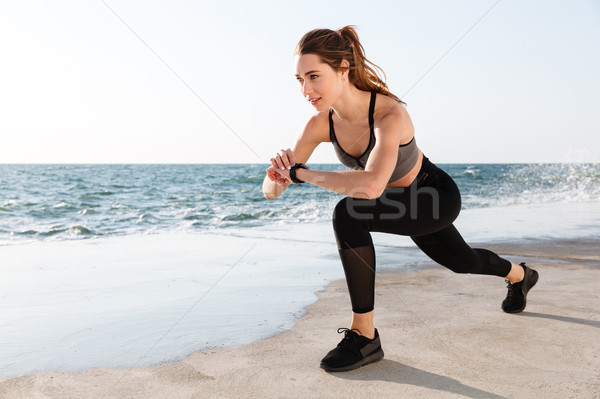 Portrait of young smiling  fitness woman checking time while doi Stock photo © deandrobot