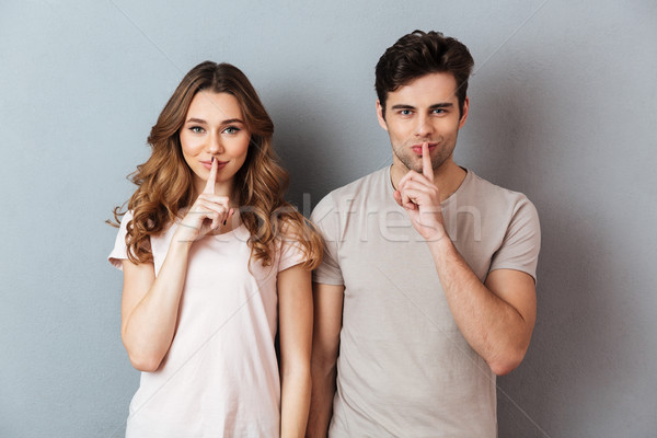 Stock photo: Portrait of a smiling couple showing peace gesture