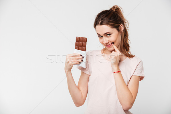 Portré csinos lány tart csokoládé szelet néz Stock fotó © deandrobot