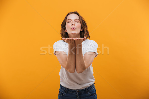 Happy young woman looking camera blowing kisses. Stock photo © deandrobot