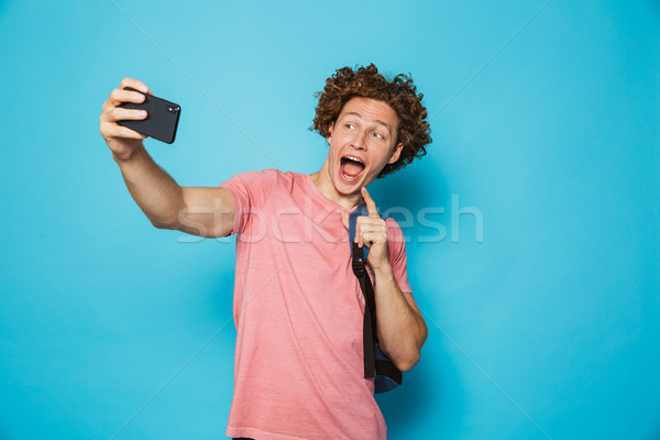 Image of caucasian youngster guy with curly hair wearing casual  Stock photo © deandrobot