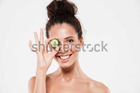 Happy woman covering her eyes with cucumber Stock photo © deandrobot