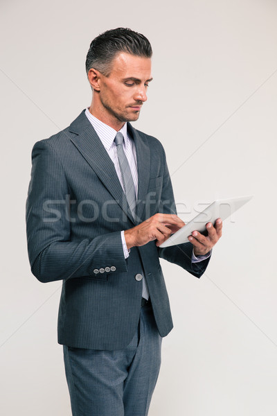 Handsome businessman using tablet computer Stock photo © deandrobot