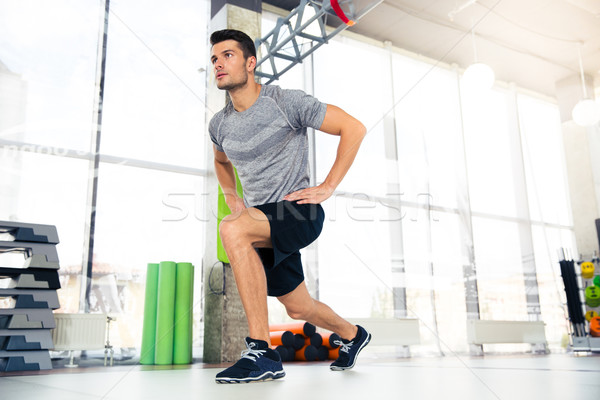 Fitness man doing warm-up exercises  Stock photo © deandrobot