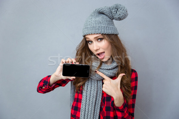 Femme pointant doigt smartphone écran portrait [[stock_photo]] © deandrobot