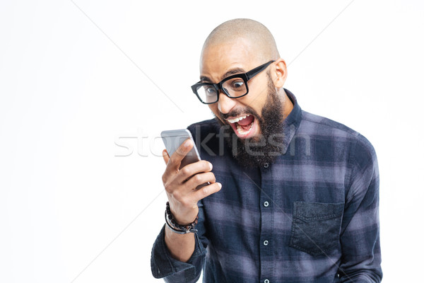 Stock photo: Shocked african american man using mobile phone and shouting 