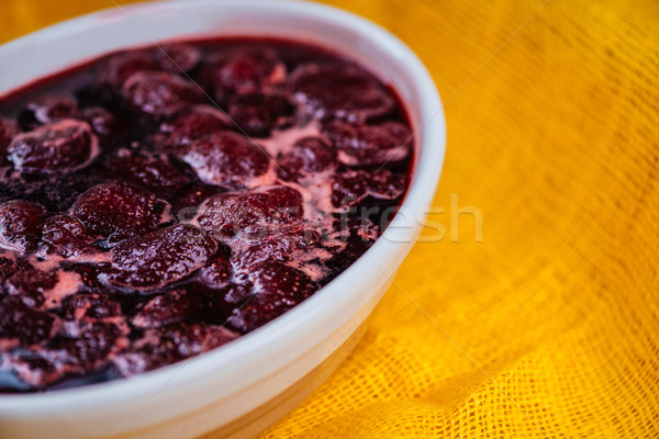 Strawberry jam with berries on yellow tablecloth Stock photo © deandrobot