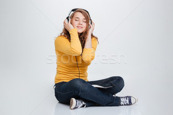 Happy woman listening music in headphones Stock photo © deandrobot