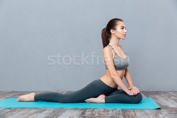 Young smiling girl in sportswear sitting on splits Stock photo © deandrobot