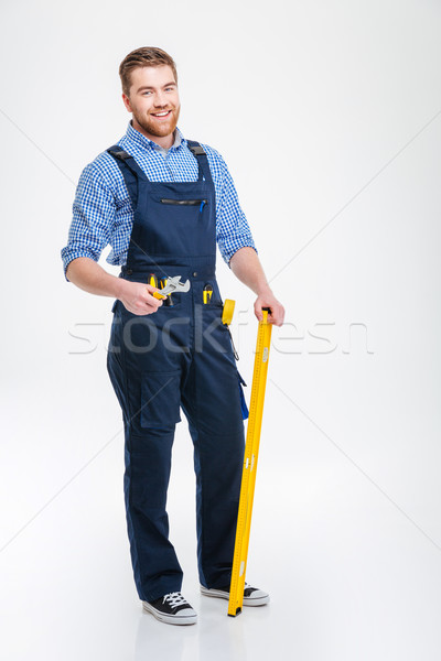 Happy male builder standing with equipment Stock photo © deandrobot