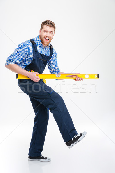 Stock photo: Cheerful male builder playing with waterpas
