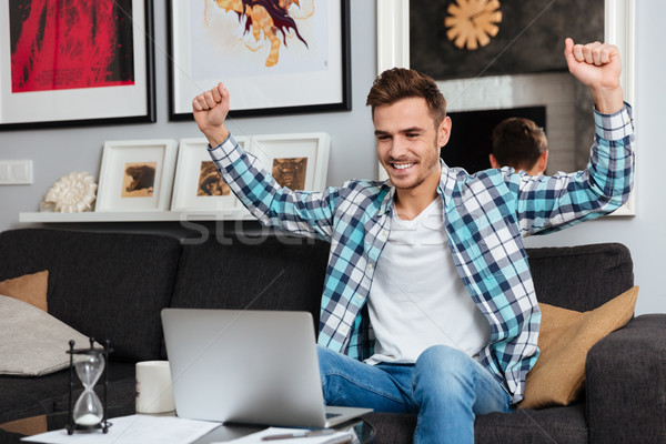 快樂 怒髮衝冠 男子 坐在 沙發 使用筆記本電腦 商業照片 © deandrobot