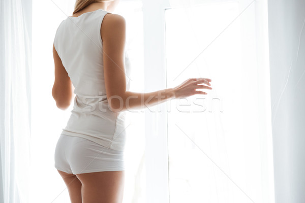 Ver de volta mulher olhando janela casa relaxar Foto stock © deandrobot