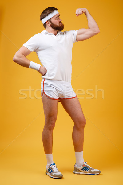 Vertical image of retro sportsman showing bicep Stock photo © deandrobot