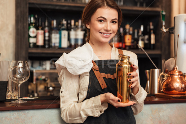 Beautiful young woman standing in cafe holding shaker Stock photo © deandrobot