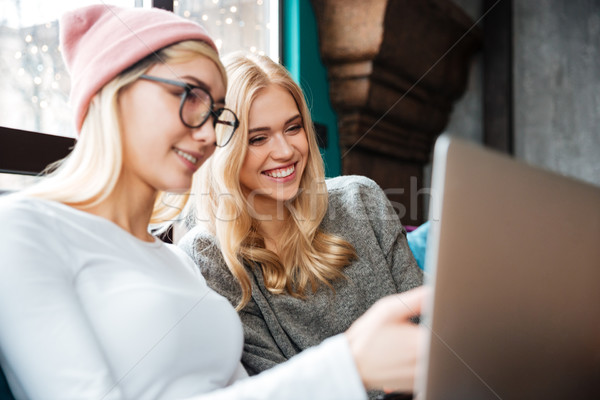 Iki kadın oturma kafe dizüstü bilgisayar kullanıyorsanız fotoğraf genç Stok fotoğraf © deandrobot