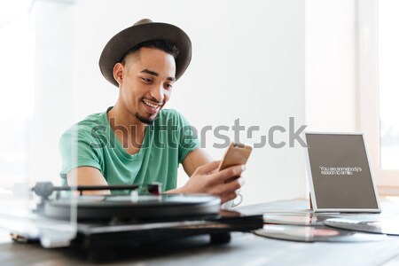 Smiling African man talking on smartphone Stock photo © deandrobot