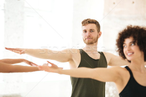 Mixed group of fitness people doing exercises Stock photo © deandrobot