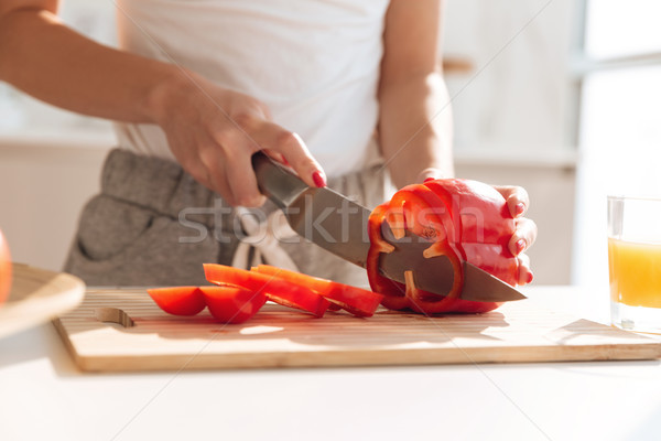 Close up portrait of young woman slicing capsicum Stock photo © deandrobot
