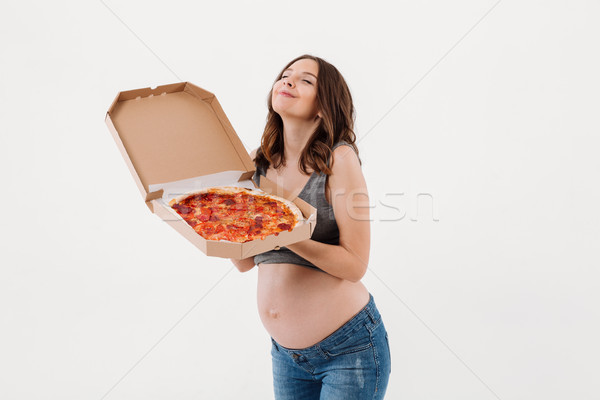Happy pregnant woman holding pizza and smells it Stock photo © deandrobot