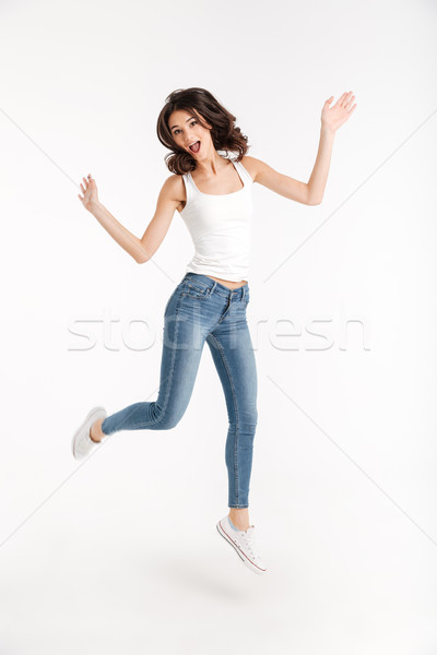 Full length portrait of an excited girl dressed in tank-top Stock photo © deandrobot