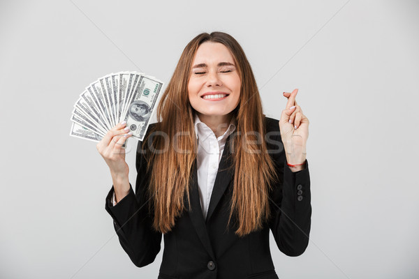 Happy lady with closed eyes holding dollars and making prey gesture isolated Stock photo © deandrobot