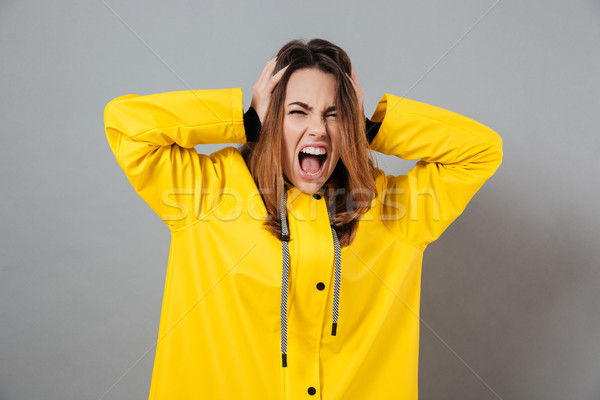 Portrait of an angry girl dressed in raincoat Stock photo © deandrobot