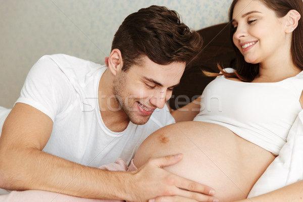Fericit gravidă sotie pat sotul dormitor Imagine de stoc © deandrobot