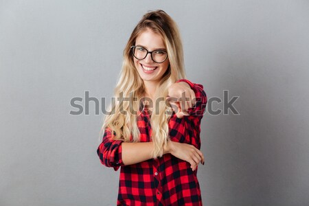 Portrait of a happy pretty girl holding fake eyeglasses Stock photo © deandrobot