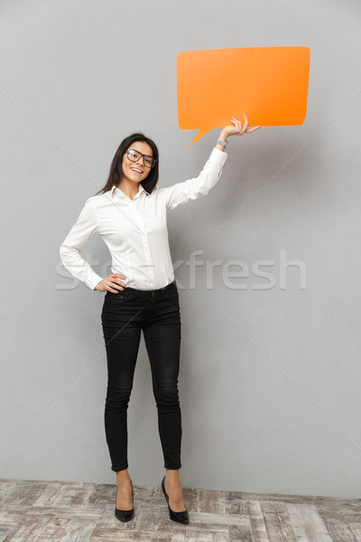 Full length image of business woman wearing formal outfit holdin Stock photo © deandrobot