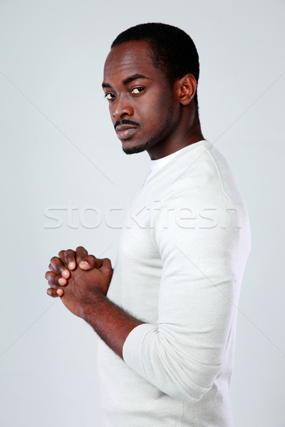 Side view portrait of a serious african man over gray background Stock photo © deandrobot