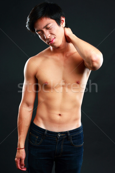 Stock photo: Asian man suffering from neck pain on black background