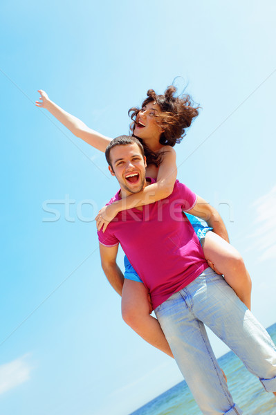 Happy young couple in casual cloths at the beach in sunny weather Stock photo © deandrobot