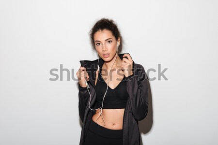 Young woman holding shoes over gray background Stock photo © deandrobot