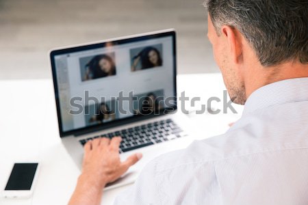 Vedere din spate portret tânăr folosind laptop la locul de muncă calculator Imagine de stoc © deandrobot