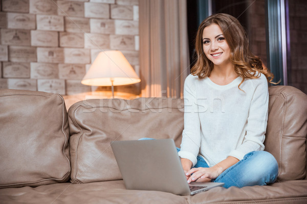Woman sitting on the couch with laptop compute Stock photo © deandrobot