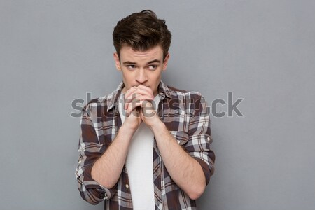 Koncentrált fiatalember imádkozik csukott szemmel hangsúlyos jóképű Stock fotó © deandrobot