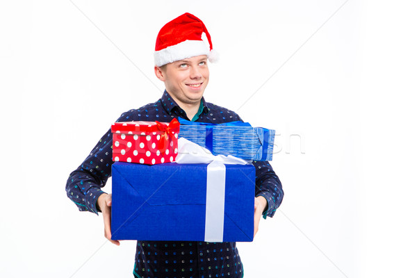 Inspired foretasted young man in santa claus hat holding presents  Stock photo © deandrobot