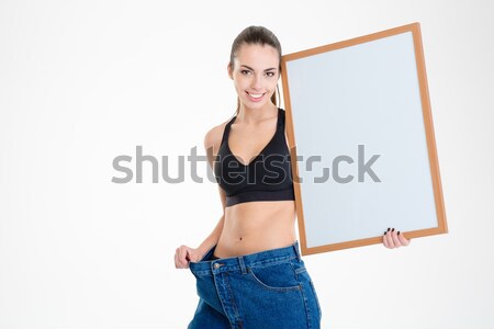 Shocked slim fitness girl in jeans that became too big  Stock photo © deandrobot