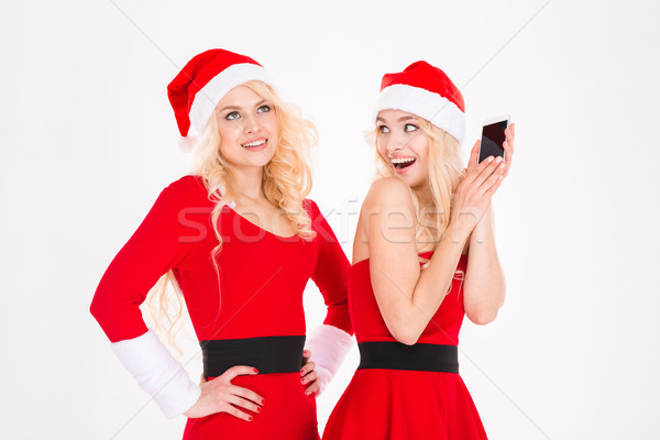 Funny playful sisters twins in santa claus dresses and hats  Stock photo © deandrobot