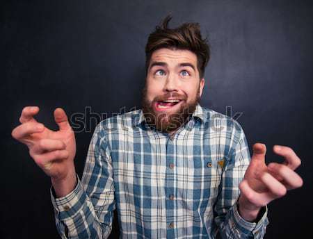 Shouting man standing over chalkboard background with drawn horns Stock photo © deandrobot