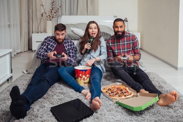 Souriant amis manger pizza jouer ordinateur [[stock_photo]] © deandrobot